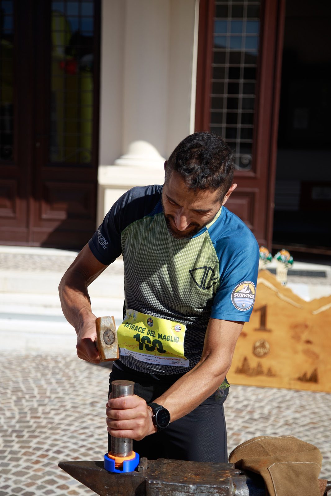 Un finisher batte con il maglio la sua medaglia sull'incudine