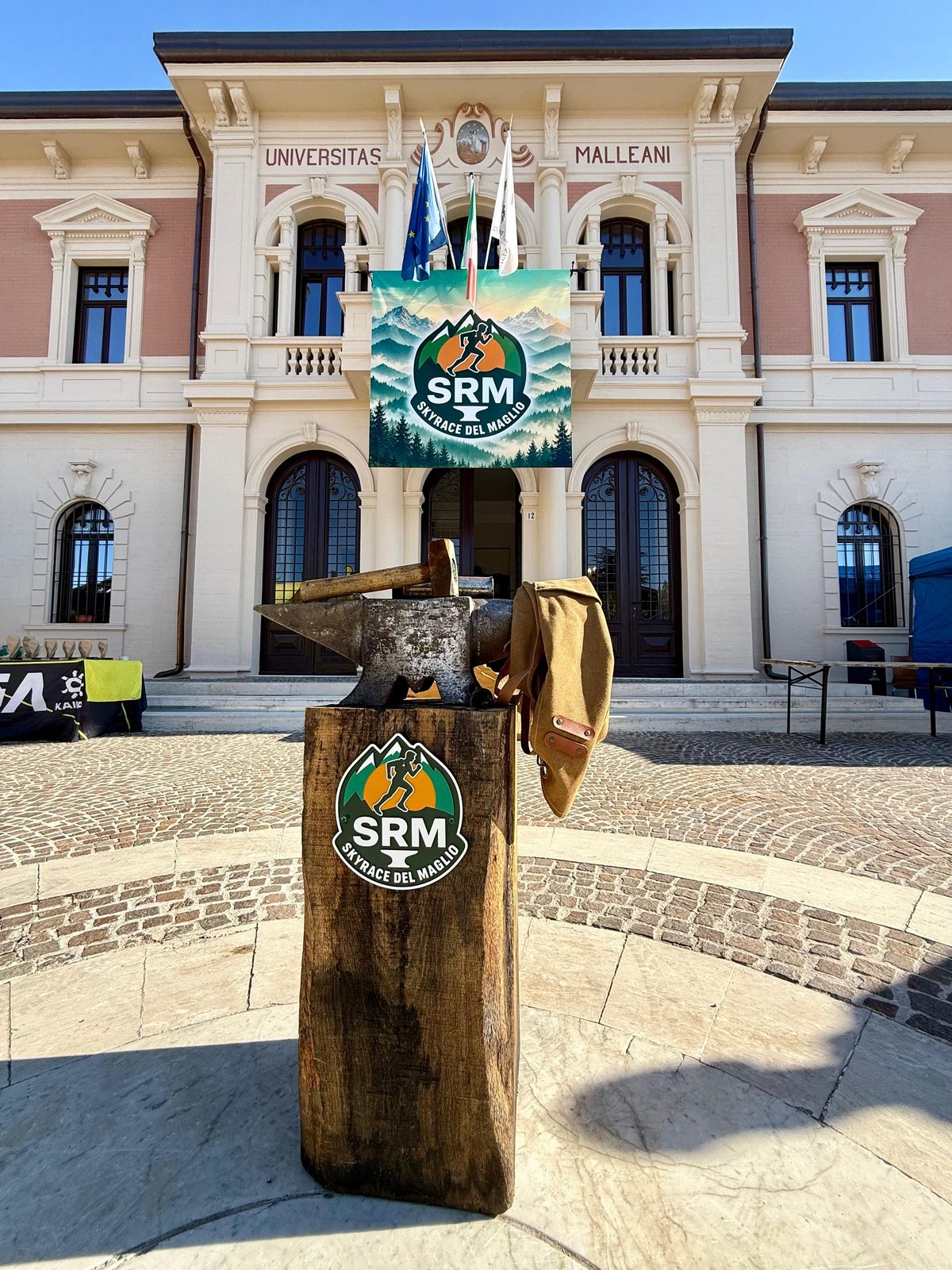 L'incudine sul ceppo con l'emblema SRM, davanti al Municipio e al gonfalone della gara